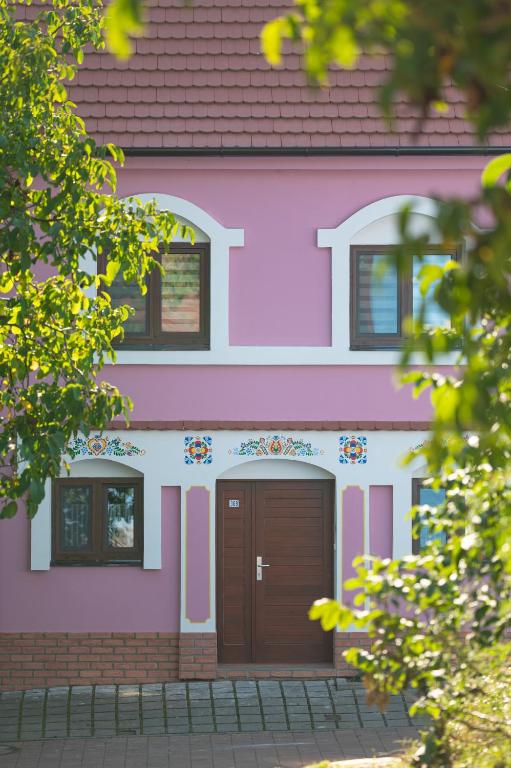 a pink house with a brown door at Sklípek Nechory in Prušánky