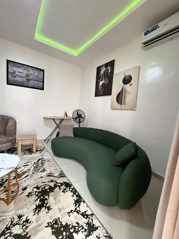 a living room with a green couch and a table at Waterfront 3BR Lekki Lagoon View in Maiyegun