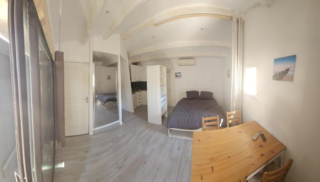 a bedroom with a bed and a wooden table at cosy studio in Saint-Maximin-la-Sainte-Baume