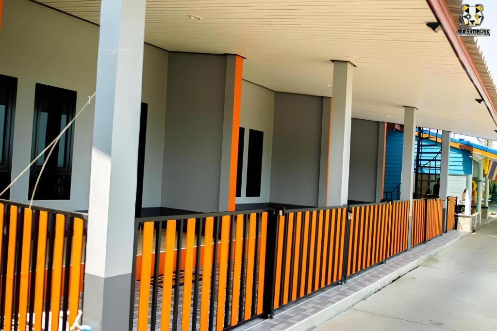 an empty hallway of a building with an orange fence at Limlay House in Ban Suan On
