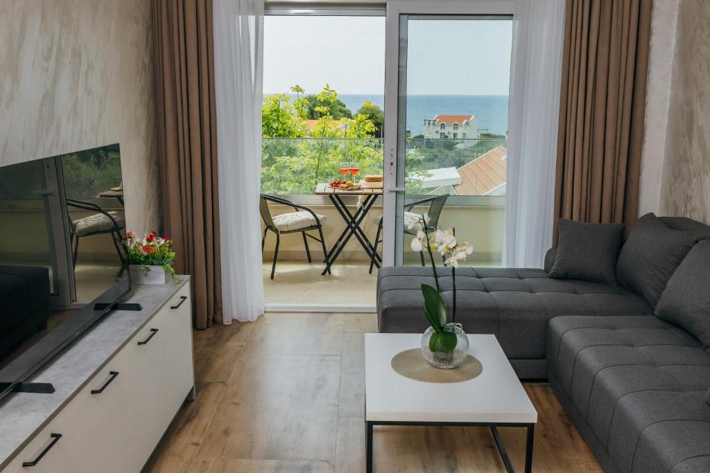 a living room with a couch and a tv at Apartments Via Mare in Petrovac na Moru