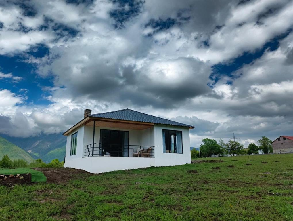 a small house on top of a grass field at Villa Tba near Borjomi, Tsemi and Sadgeri in Tsemi