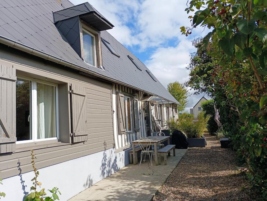 a side view of a house with a table next to it at Les Roses d Antan - 2 gîtes in Néville