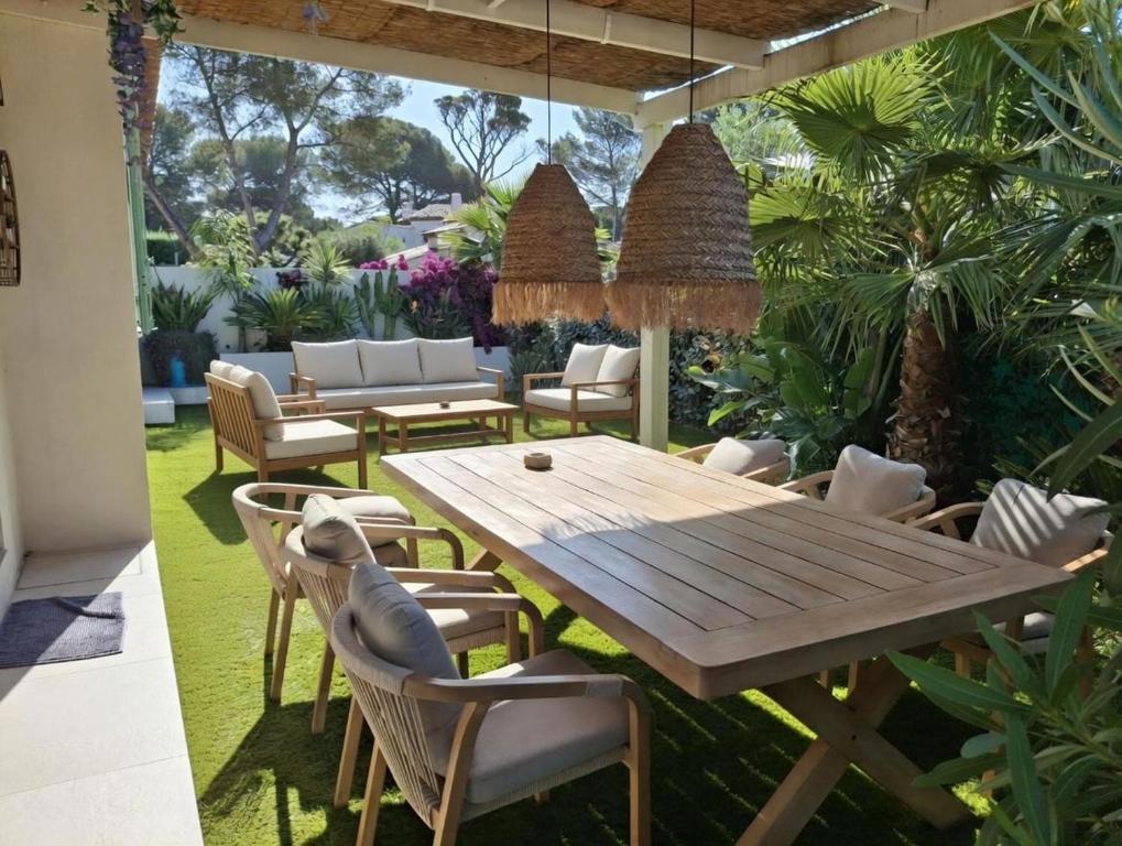 a patio with a wooden table and chairs at La Petite Bergerie in Fréjus