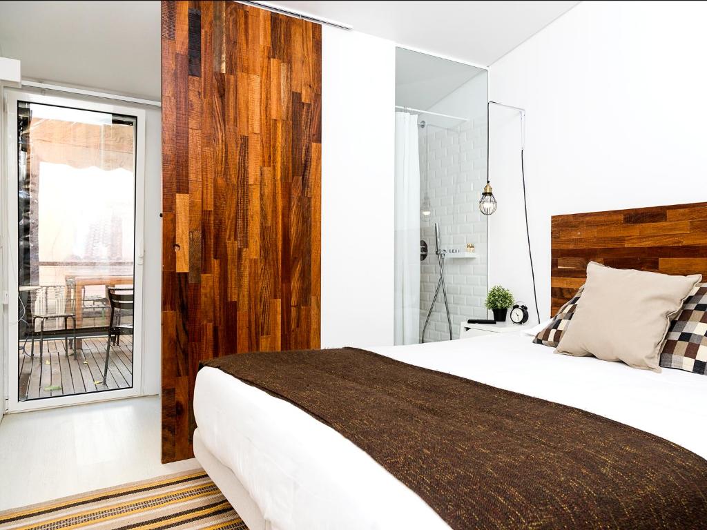 a bedroom with a large bed and a window at Santa Bica Eat Drink & Sleep in Lisbon
