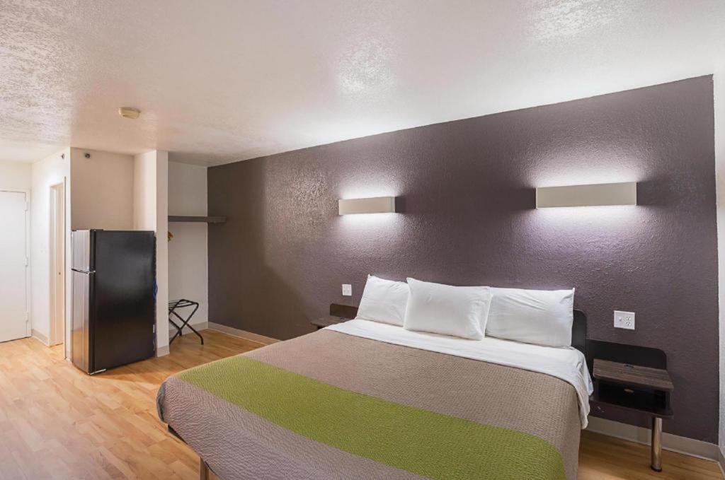 a bedroom with a large bed and a black wall at Studio 6 Buttonwillow, CA in Bowerbank