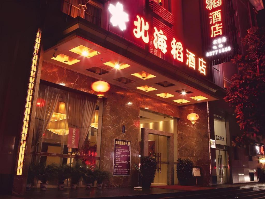a restaurant with a sign on the front of it at night at Behito Hotel in Dongguan