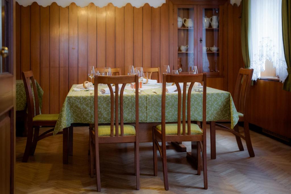 a dining room table with a green table cloth and chairs at Gostilna Repovž, Restaurant Repovž in Šentjanž