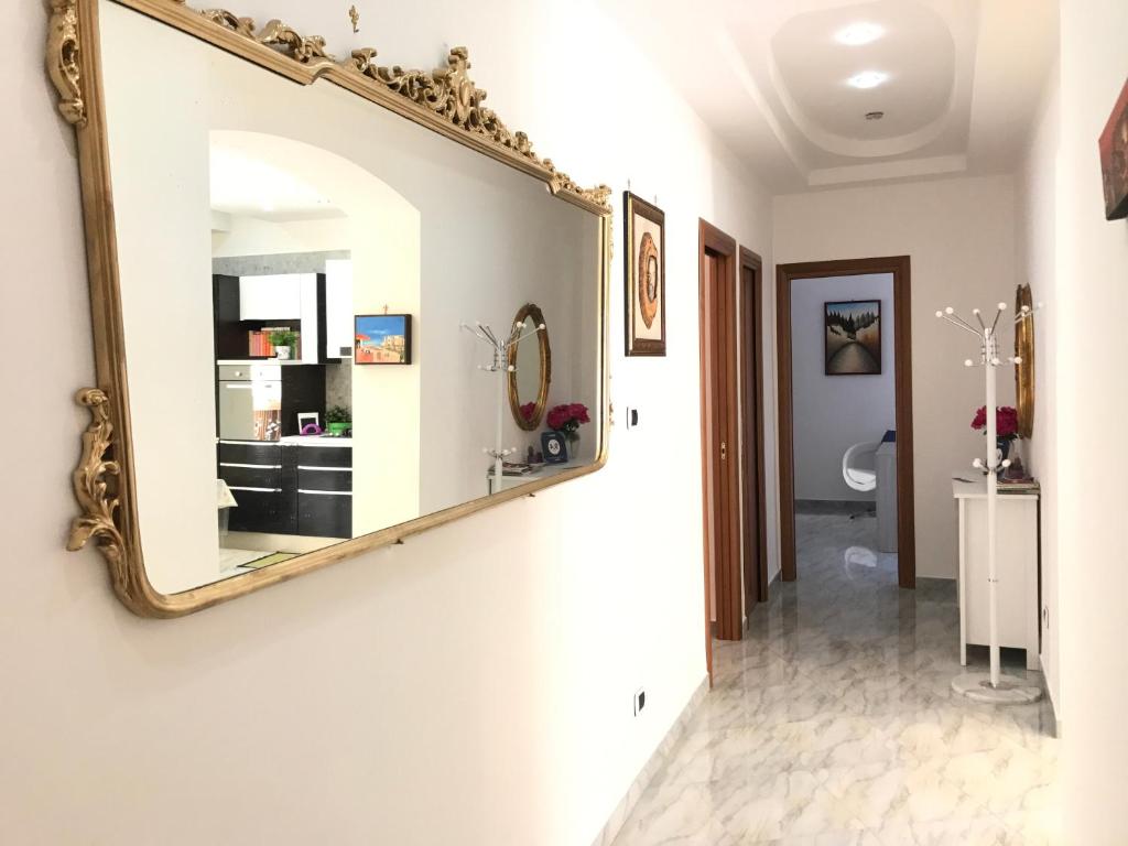 La salle de bains est pourvue d'un miroir accroché au mur. dans l'établissement Supera Napoli Apartment, à Naples