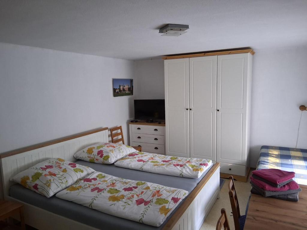 a bedroom with two beds and a dresser in it at Bungalow im Künstlergarten in Bad Muskau