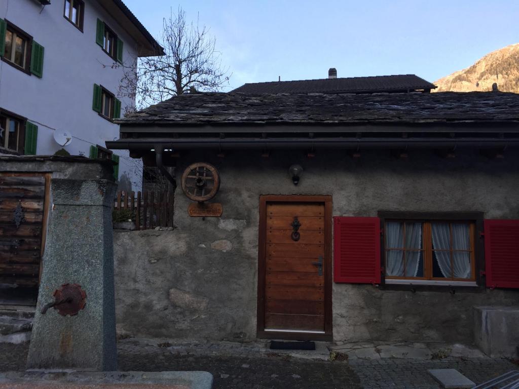 stary dom z drzwiami i dwoma oknami w obiekcie Fravgia veglia w mieście Andeer