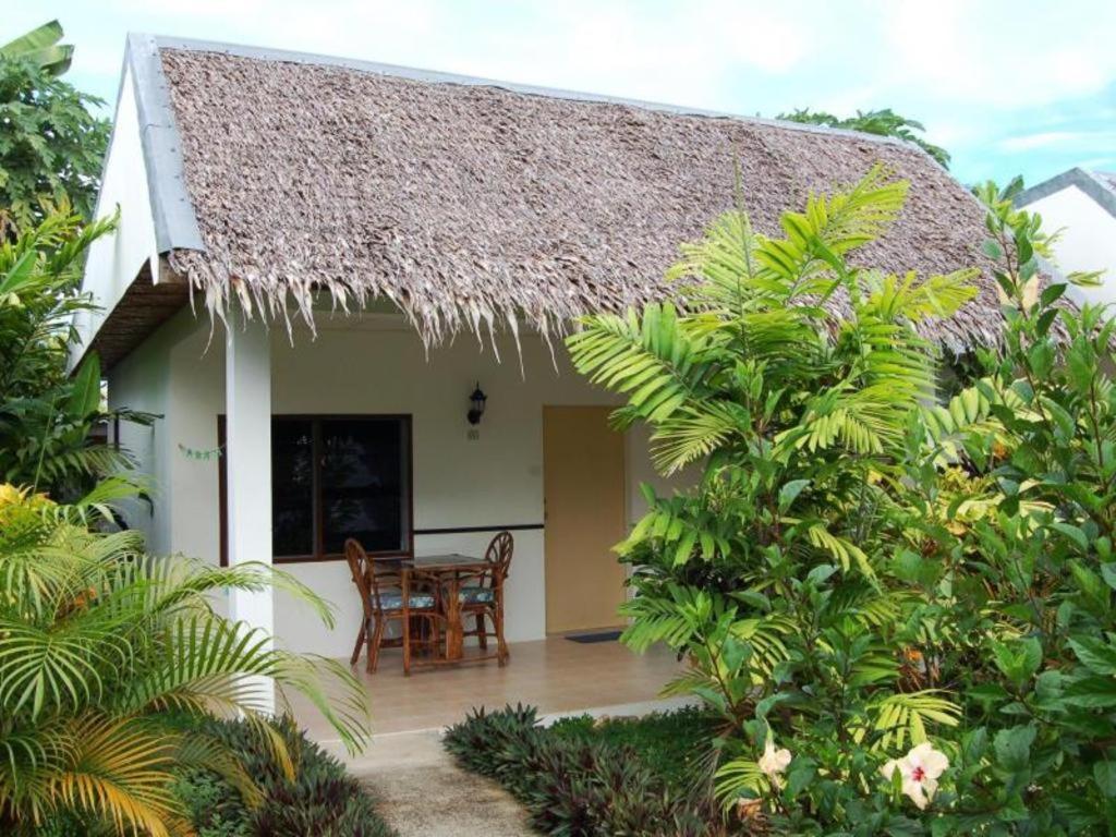 a small white house with a table and chairs at Marcosas Cottages Resort in Basdiot