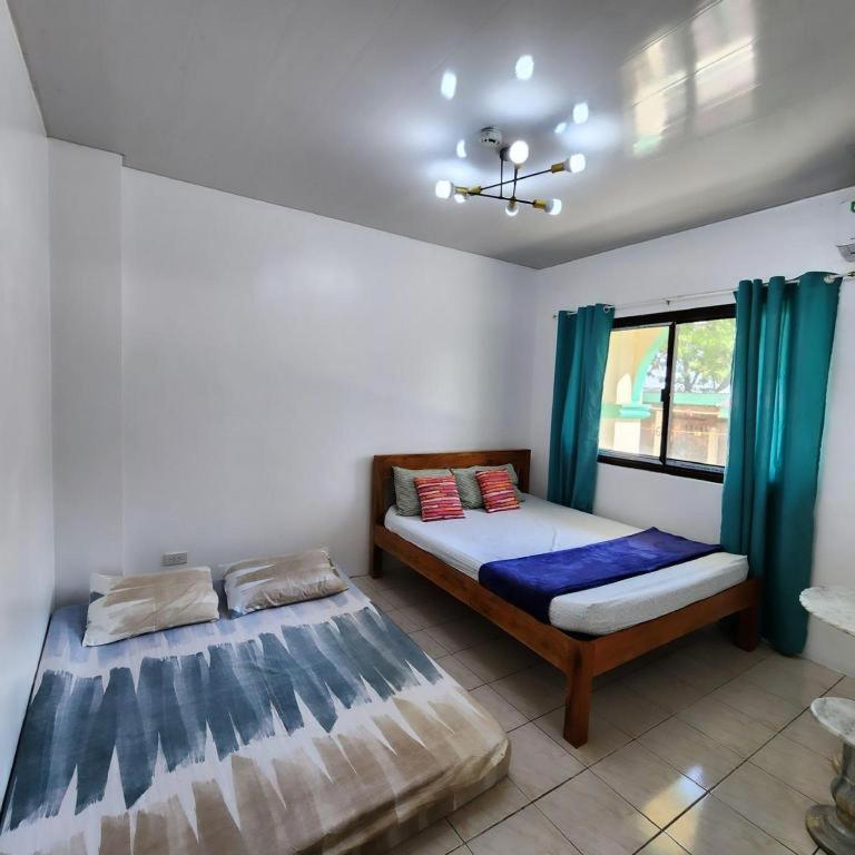 a bedroom with two beds and a window at Pertible Beach Resort in Tondol