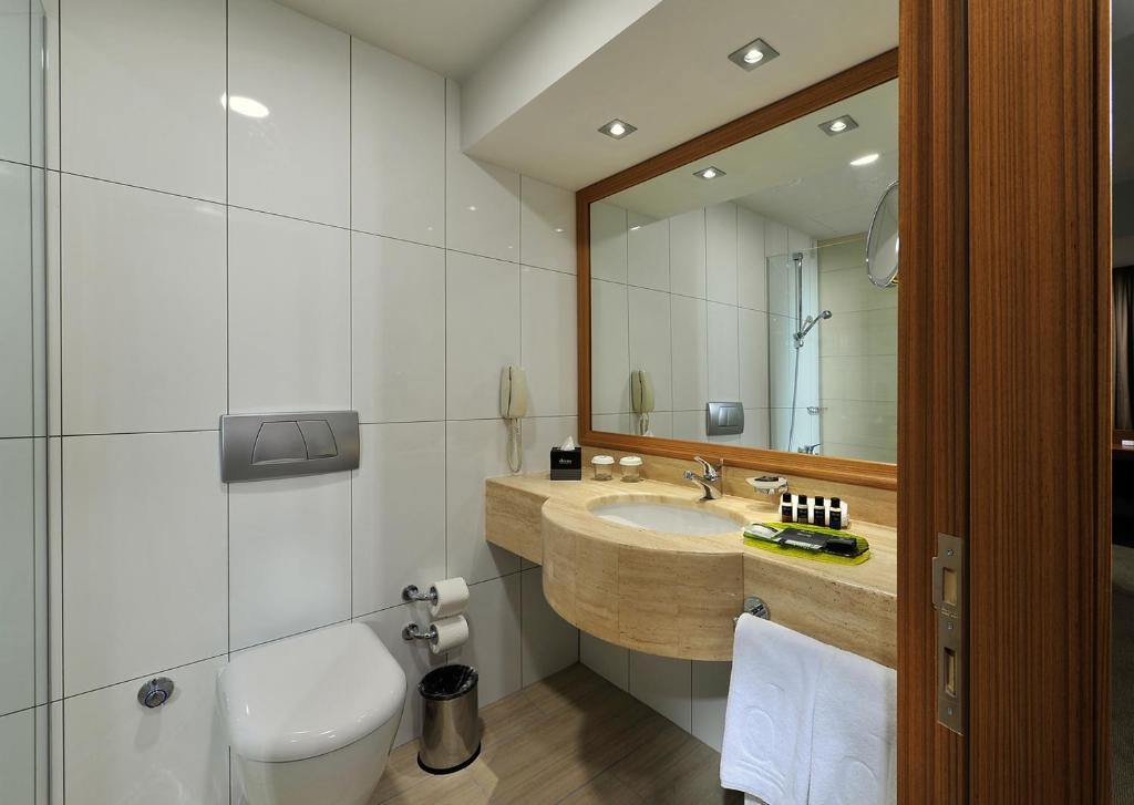 a bathroom with a sink and a toilet and a mirror at Divan Istanbul City in Istanbul