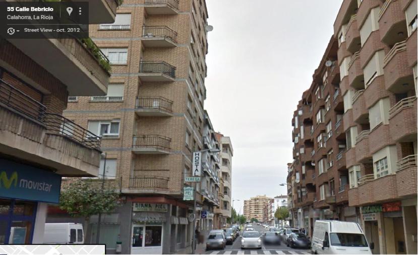 une rue urbaine avec des bâtiments et des voitures dans la rue dans l'établissement Pension Teresa, à Calahorra