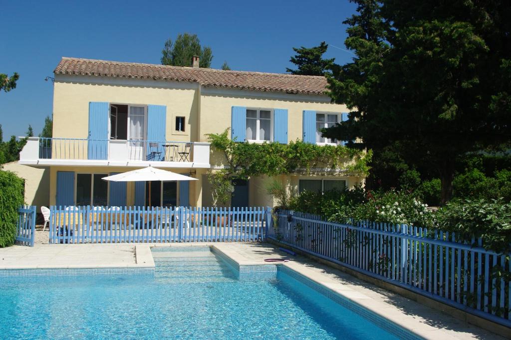 a house with a blue fence and a swimming pool at La Luberonne in Lourmarin