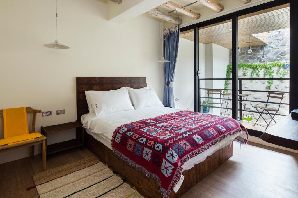 a bedroom with a bed with a red blanket at Haku Beach Days Inn in Nanwan