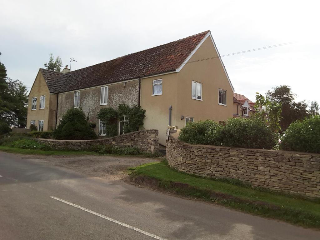 a house with a stone wall next to a street at Windylands in Chipping Sodbury