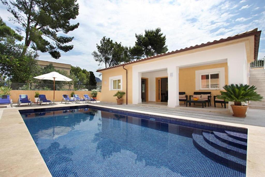 a swimming pool in front of a house at Can Medina in Pollença
