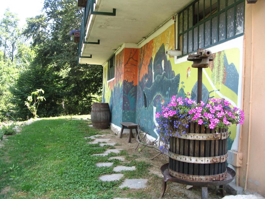 a building with a painted wall with flowers in a barrel at B&B Pian Savin in Giaveno
