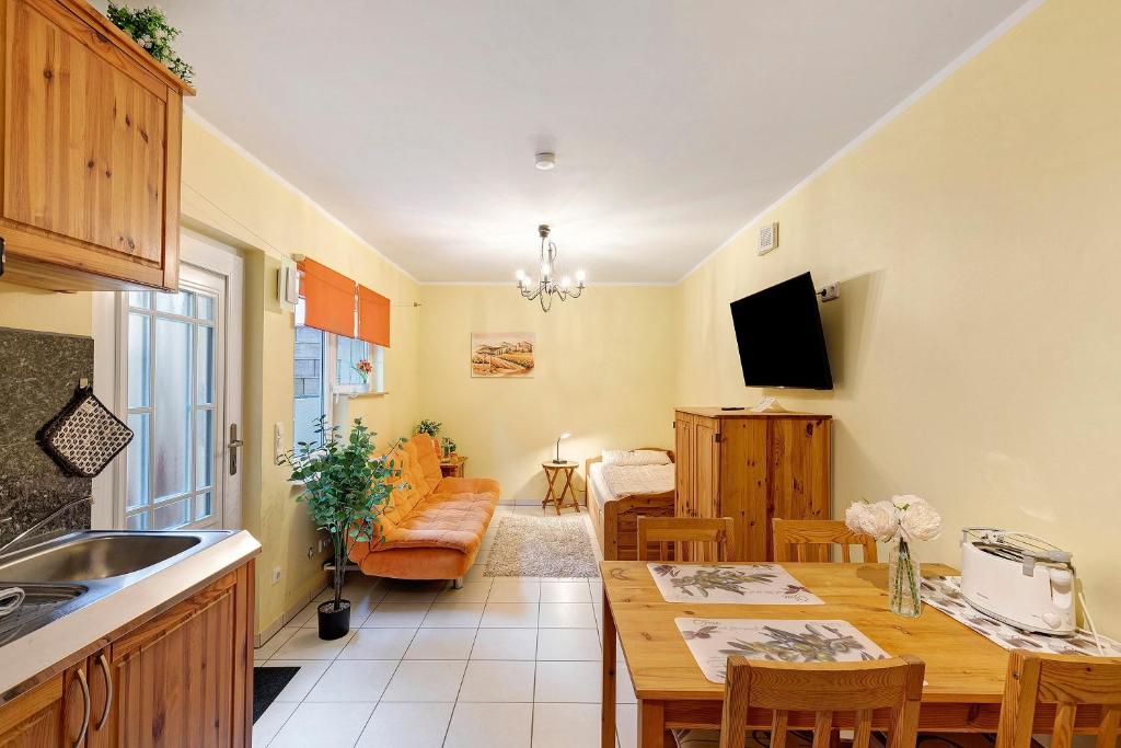 a kitchen and living room with a table and a dining room at Villa am Keltenberg - El Sol in Glauburg
