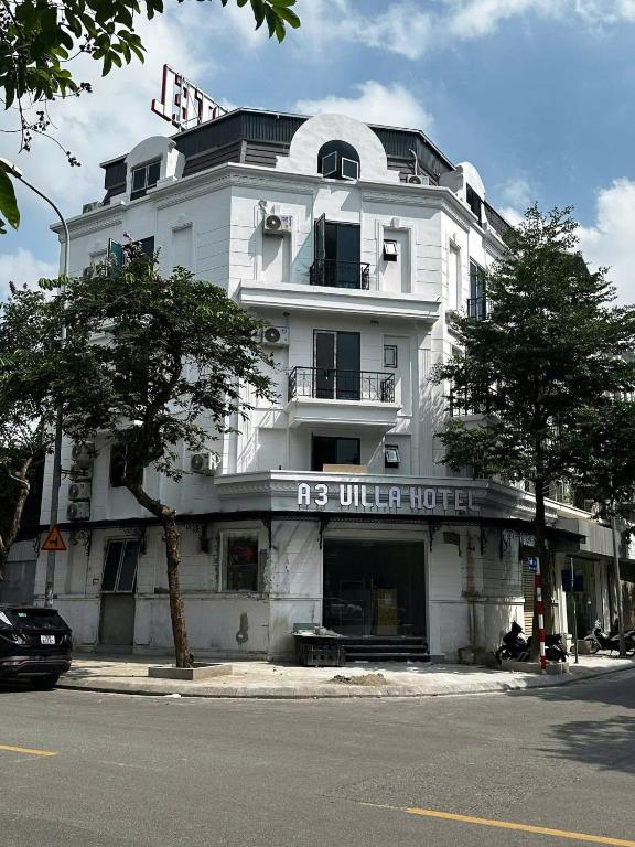 a white building on the corner of a street at A3villa Hotel in Thạch Cầu