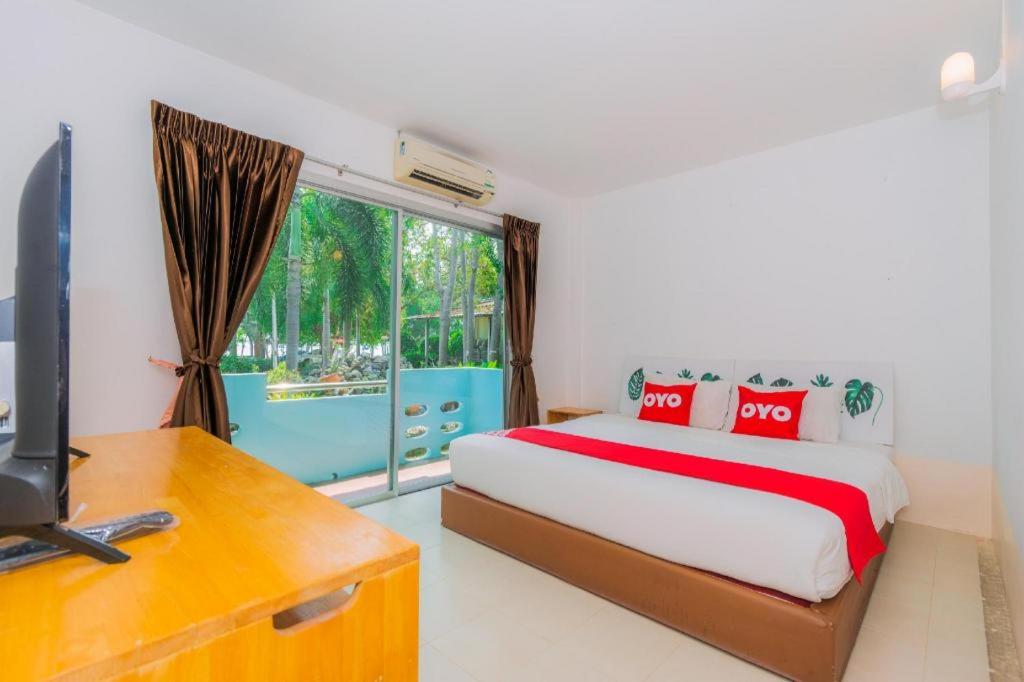 a bedroom with a bed and a desk and a television at Koh Lak Resort in Prachuap Khiri Khan
