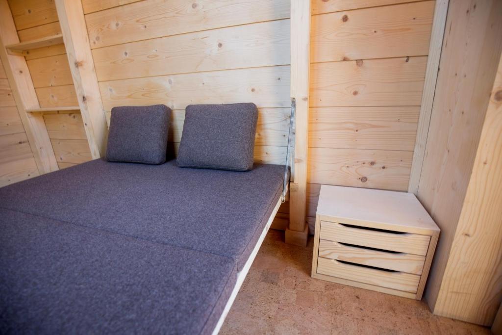 a small bedroom with a bed and a night stand at Micro Cabana Rotativa in Bragança