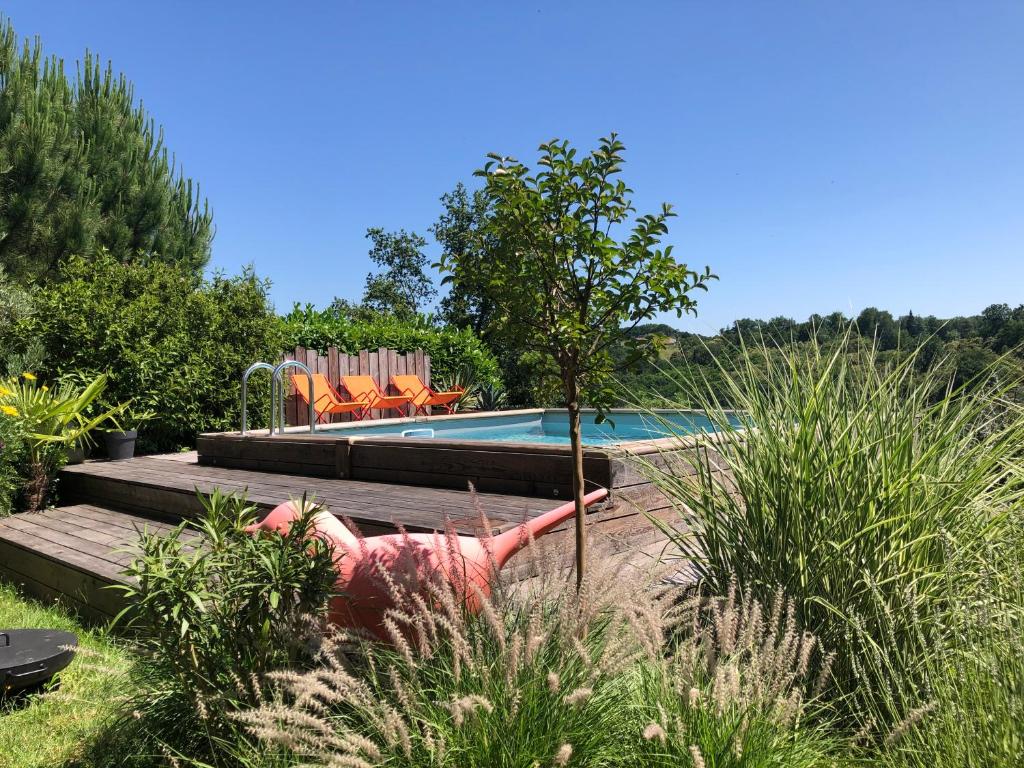 a swimming pool in a yard with chairs next to it at Hôtel Particulier Nontron - chambre d'hôtes et meublés de tourisme in Nontron