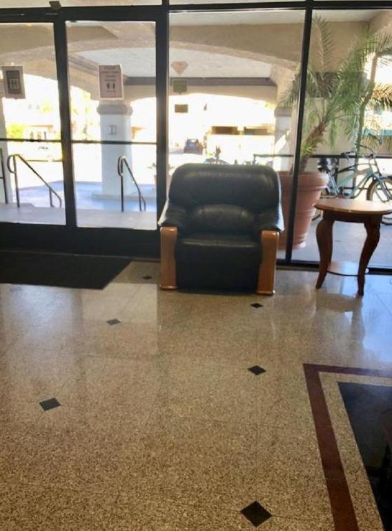 a black chair sitting in a room with a table at Huntington Beach Inn in Huntington Beach