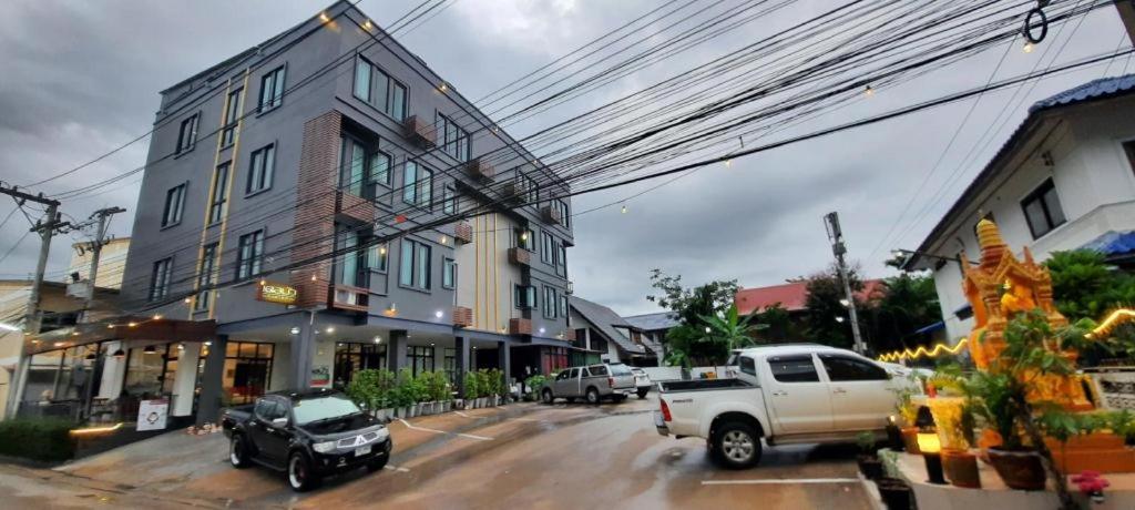 a white truck parked on a street next to a building at Debua Mahasarakham in Maha Sarakham