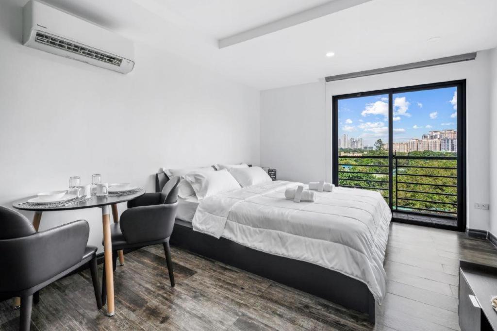 a bedroom with a bed and a table and a window at Espacio Hotel in Manila