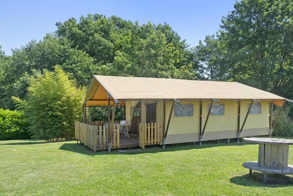 a gazebo with a table in a yard at Lodge La Forêt in Saint-Sauveur