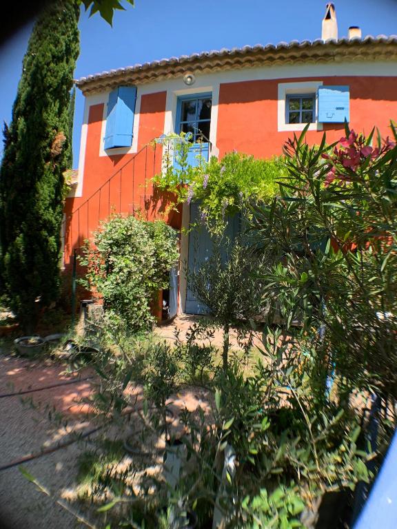 an orange house with bushes in front of it at Mas Valentine in Roquemaure