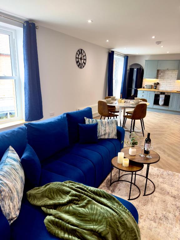 a living room with a blue couch and a table at Luxury Holt Duplex with Bath Suite in Holt