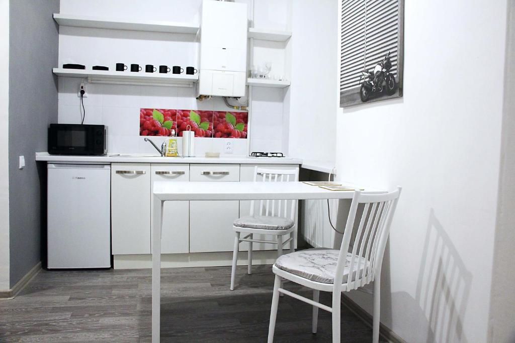 リヴィウにあるComfortable apartament in the centrの白いキッチン(白いテーブル、椅子2脚付)