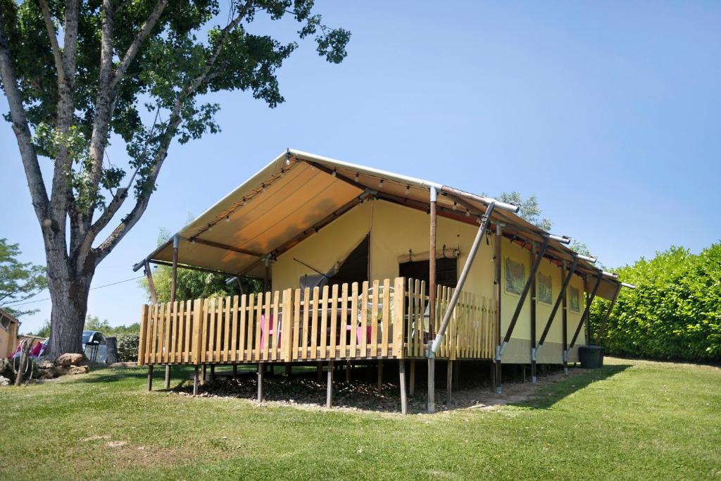 a small house with a porch in a park at Lodge Les Étoiles in Saint-Sauveur