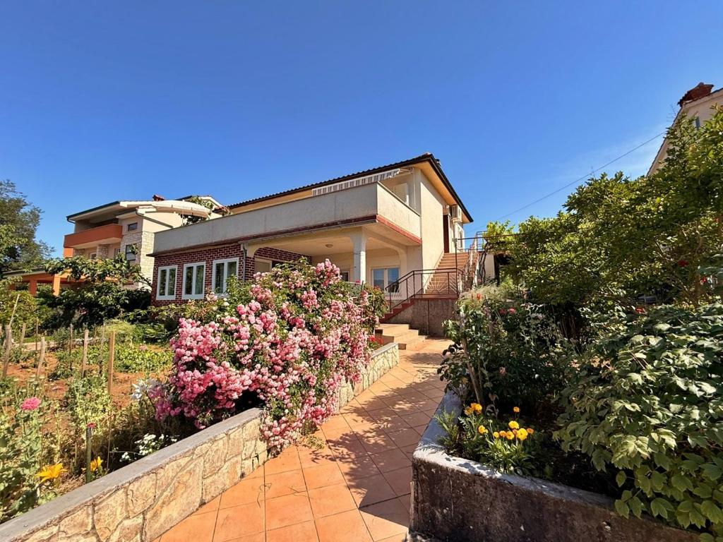 a house with some flowers in a garden at Apartments Dragica in Šilo