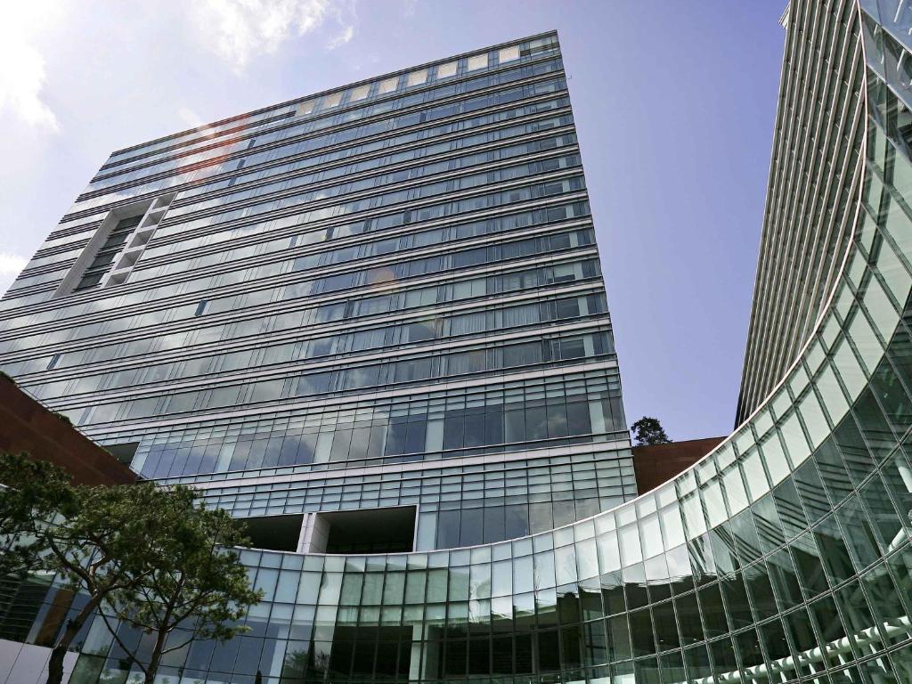 a tall office building with a lot of windows at Grand Mercure Ambassador Changwon in Changwon