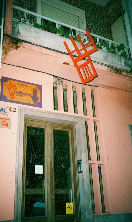 an orange sign on the side of a pink building at Collector's Home in Braga