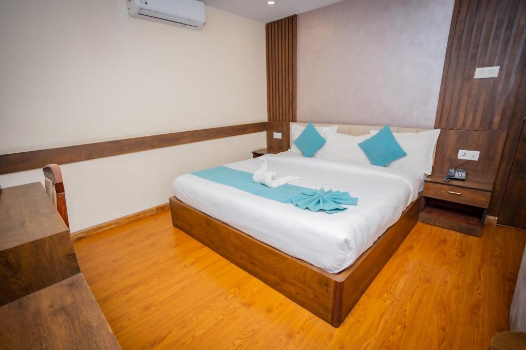 a bedroom with a large bed with blue pillows at Hotel AB Inn in Kathmandu