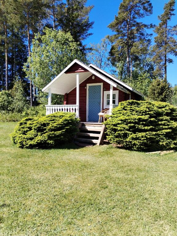 a small house with a blue door in a yard at The little cottage in Saltvik