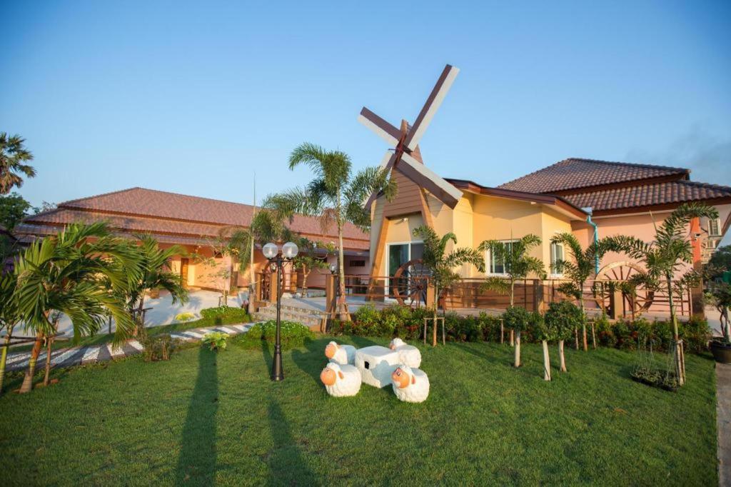 a house with a windmill in front of a yard at Naphet Resort in Phetchaburi