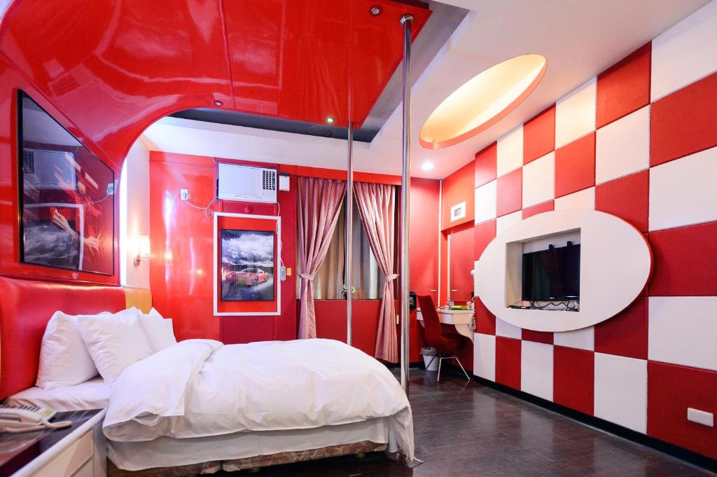 Habitación roja y blanca con cama y TV en Guest Motel-Zhubei, en Zhubei