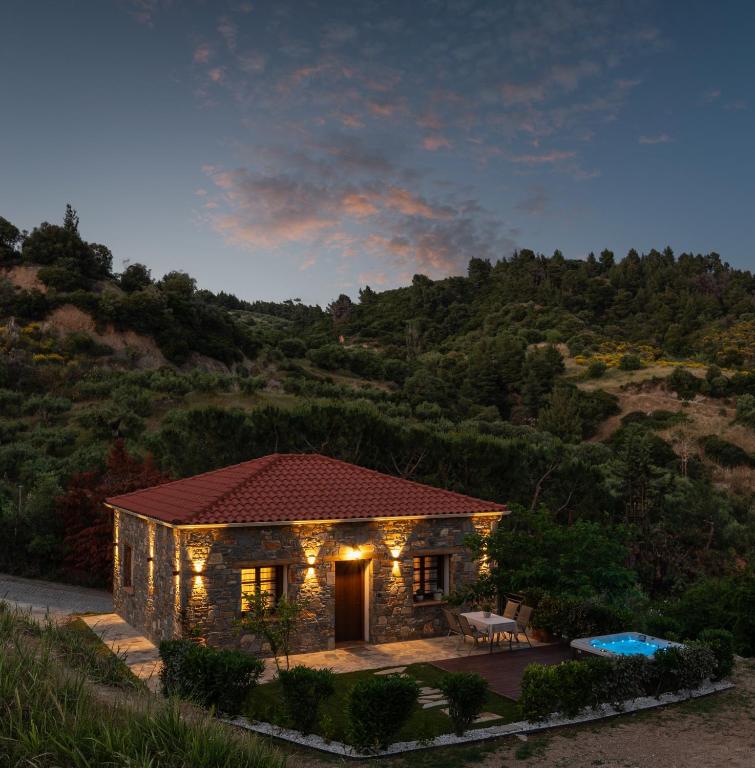 a small house with lights in front of a mountain at JIRONI VILLA in Nikiti