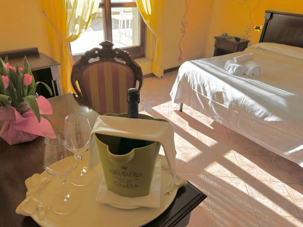 a table with a bottle of wine and glasses on it at Hotel Lugana Parco Al Lago in Sirmione