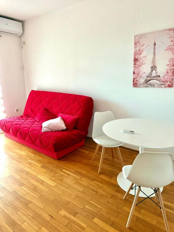 a red couch in a living room with a table at Riviera Budva Residence in Budva