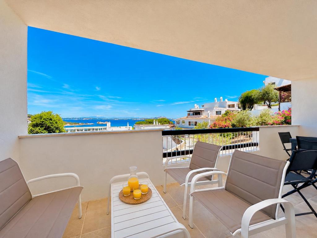 a balcony with chairs and a table with a view of the ocean at Renew Terrace RB Two Bedroom 50m from the Beach in Baja Sardinia