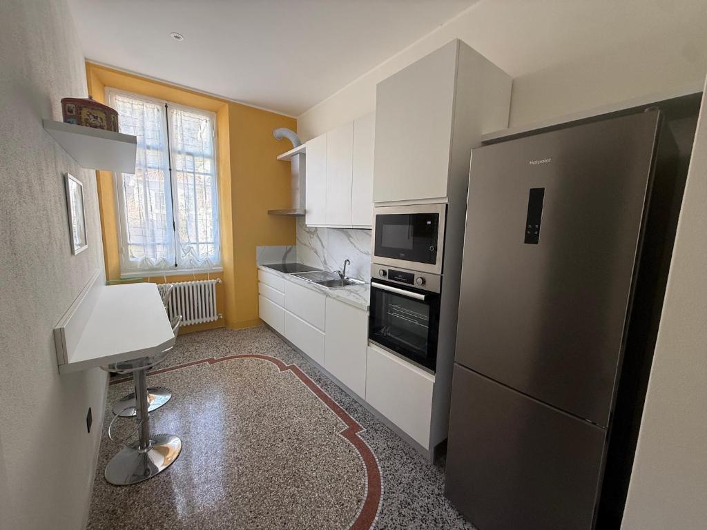 a kitchen with a stainless steel refrigerator and a microwave at Family villa con terrazza e relax in Pietra Ligure