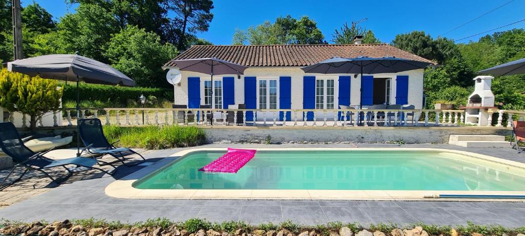 a house with a swimming pool in front of a house at Gîte-La mare aux étoiles in La Douze